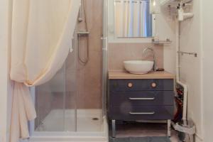 a bathroom with a glass shower with a sink and a vanity at Le Lexa in Vindelle