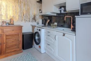 a kitchen with a washing machine and a sink at Le Lexa in Vindelle