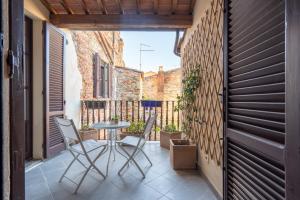 a small courtyard with a table and chairs on a balcony at Palazzo Cofani in Arezzo