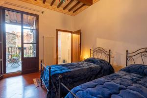 a bedroom with two beds and a door to a patio at Palazzo Cofani in Arezzo