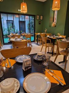 a dining room with a table with plates on it at Hotel Du Cygne Tours in Tours