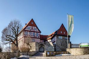 a large house with a stone wall at Zum weißen Roß in Hausen