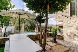 a patio with an umbrella and a pool at Casa Real De Cima in Fervença