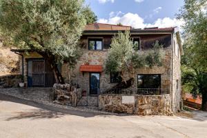 a stone house with a tree in front of it at Casa Real De Cima in Fervença