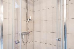 a shower with a glass door and a shower coil at Fuchsbau In Der Ktv in Rostock +14 photos