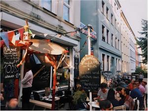 a crowd of people sitting at tables outside a restaurant at Fuchsbau In Der Ktv in Rostock