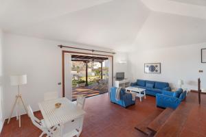 a living room with a blue couch and a table at Villa del Mar Palm Mar in Palm-Mar