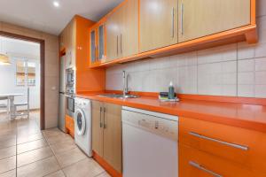 a kitchen with orange cabinets and a washer and dryer at Villa Atlantic Ocean Private Pool in Corralejo