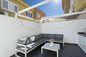 a living room with a couch and a table at Sunset Villa Meloneras in Maspalomas
