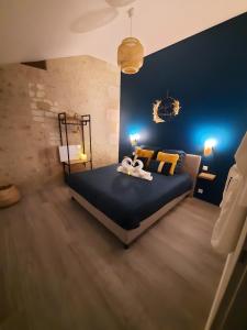 a bedroom with a bed with blue walls and yellow pillows at La Folie Romantique, Avec Spa in Sublaines