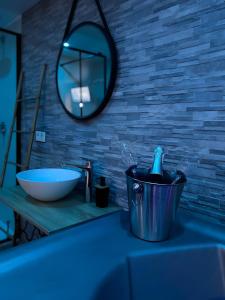 a bathroom counter with a sink and a mirror at La Folie Romantique, Avec Spa in Sublaines