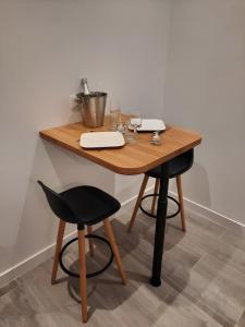 a wooden table with two chairs and a laptop on it at La Folie Romantique, Avec Spa in Sublaines