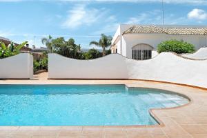 a swimming pool in front of a house at Chalet Fuente3 piscina común famila in Conil de la Frontera
