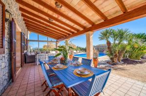a blue table and chairs on a patio with a pool at Las Naranjas in Muro