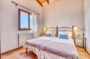 a bedroom with a large bed and a window at Las Naranjas in Muro +33 photos