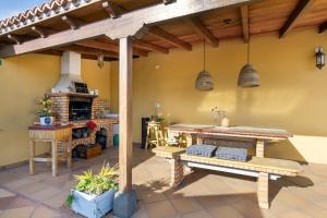 a patio with a table and benches in a room at Viento de Sal in Mazo