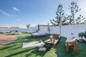 a backyard with a lawn with chairs and an umbrella at Viento de Sal in Mazo