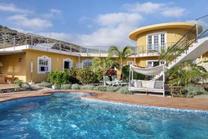 a villa with a swimming pool and a house at Viento de Sal in Mazo