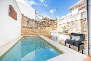 a swimming pool in a backyard with a tv on a wall at Cal Rei in Inca