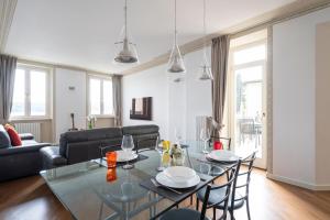 a living room with a glass table and chairs at Aa Apartments La Gioconda in Salò