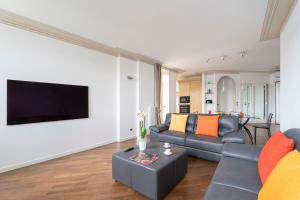 a living room with a couch and a flat screen tv at Aa Apartments La Gioconda in Salò