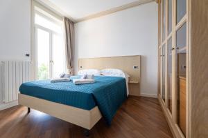 a bedroom with a bed with blue sheets and a window at Aa Apartments La Gioconda in Salò