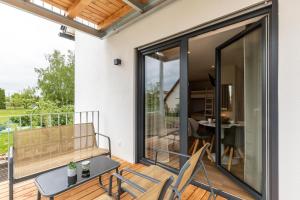 a balcony with sliding glass doors and a table and chairs at Fewo Parkside S4 - 8Min Legoland in Günzburg