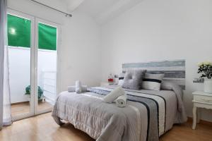 a white bedroom with a bed and a large window at Villa Españolillas in Olvera +21 photos