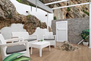 a room with white chairs and a white door at Villa Españolillas in Olvera