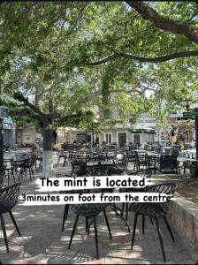 Eine Gruppe von Tischen und Stühlen unter einem Baum in der Unterkunft The mint in Politika