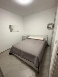 a bedroom with a bed in a white room at Appartamenti Flora in Castelsardo