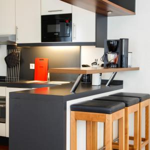 a kitchen with a counter with stools at Ferienhaus Jümmers - Pidder in Horumersiel