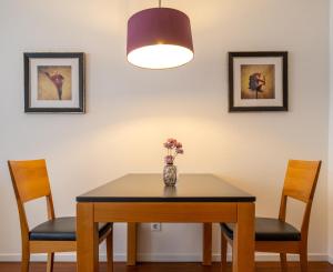 a dining room table with two chairs and a vase with flowers at Ferienhaus Jümmers - Pidder in Horumersiel +4 photos