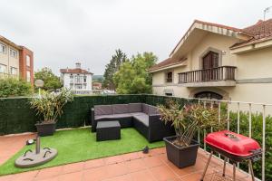 a small backyard with a couch and grass at Surf House Gama in Gama