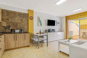 a kitchen and living room with a table and chairs at La Octava Isla in Puertito de Güímar
