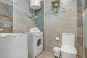 a bathroom with a washing machine and a toilet at La Octava Isla in Puertito de Güímar