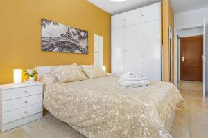 a bedroom with a bed with a yellow wall at La Octava Isla in Puertito de Güímar +17 photos