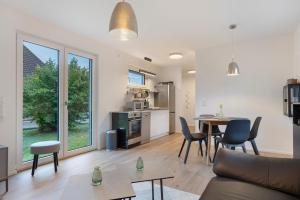 a living room with a table and chairs and a kitchen at Unterkunft für Messen und Freizeit in Hemmingen