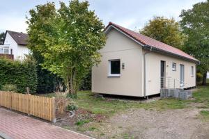 a small white house with a fence at Unterkunft für Messen und Freizeit in Hemmingen
