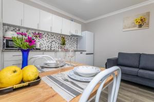 a kitchen and dining room with a wooden table with fruit on it at Oásis Fonte Grande in Santo António