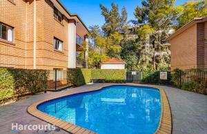 a swimming pool in front of a building at The Castle in Castle Hill