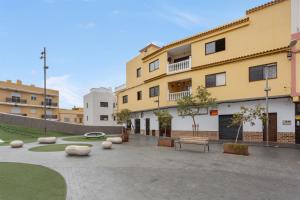 a building with a park in front of it at Luxury Ático Plaza in Playa de San Juan