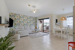a living room with a white couch and a table at Luxury Ático Plaza in Playa de San Juan