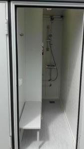a white bathroom with a shower and a glass door at Garuda yacht in Nida