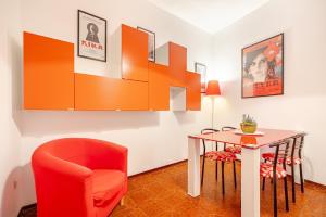 a dining room with a red chair and a table at Kina House in Marsala