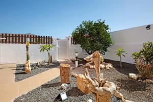 a garden with a bunch of logs and trees at Apartamento El Naranjo con jacuzzi in Tarajalejo