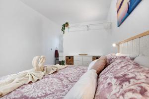 a bedroom with a large bed with a blanket at Apartamento El Naranjo con jacuzzi in Tarajalejo +13 photos