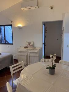 a white room with a table and chairs and a bed at Casa Dade in Tavira
