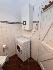 a small bathroom with a washing machine in it at Casa Dade in Tavira +12 photos