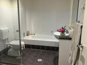 a bathroom with a tub and a toilet and a sink at The Castle in Castle Hill +6 photos